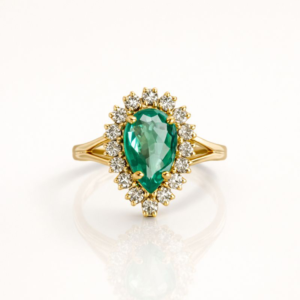 Anel ouro 18k com esmeralda em gota e halo de diamantes, 6,5g, fundo ivory.