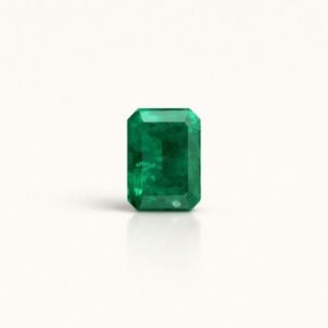 Esmeralda retangular lapidação emerald-cut, 1,2 ct, em fundo ivory com reflexo suave.