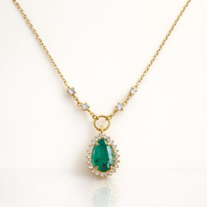 Colar ouro 18k com esmeralda em gota e halo de diamantes, com diamantes na corrente, em fundo ivory.