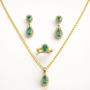 Conjunto ouro 18k com colar, brincos e anel de esmeraldas em gota e halos de diamantes, fundo ivory.