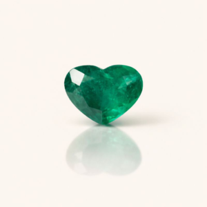 Esmeralda lapidada em coração, 2,6 ct, em fundo ivory com reflexo suave.