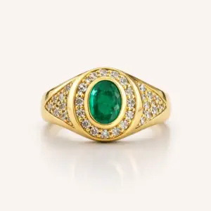 Anel em ouro 18k com esmeralda oval central e halo de diamantes, em fundo ivory.