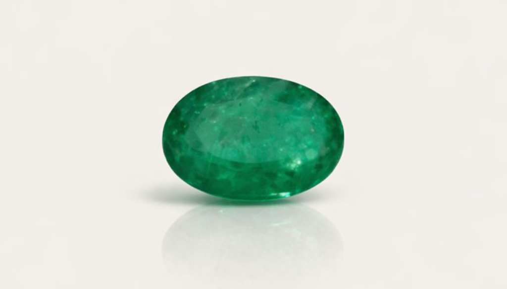 Gema verde oval lapidada sobre fundo claro